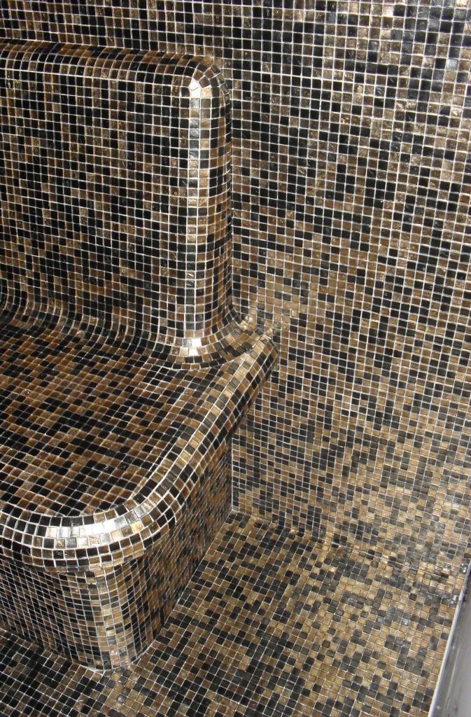 Detalhe técnico de banho turco em Monte Gordo com pastilha Onix Gold sobre estrutura Wedi e juntas alinhadas.