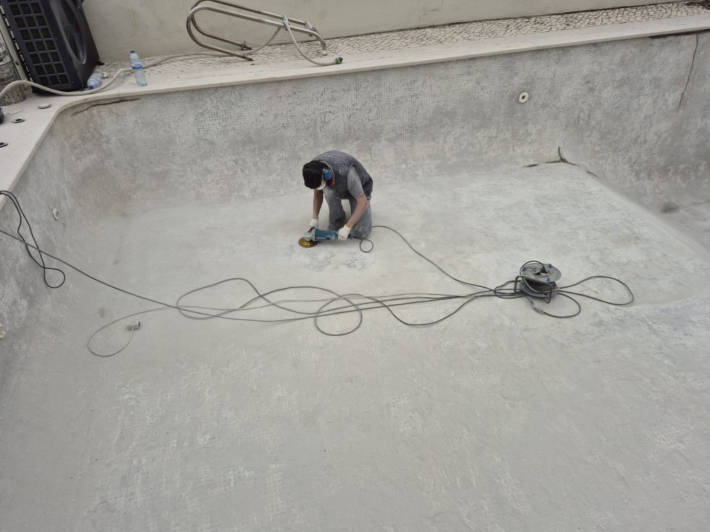 Lixamento diamantado da cuba da piscina após remoção de pastilha antiga.