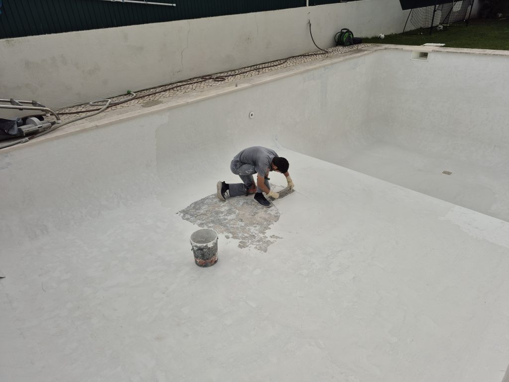 Aplicação de camada de nivelamento na cuba da piscina após reparação de fissuras