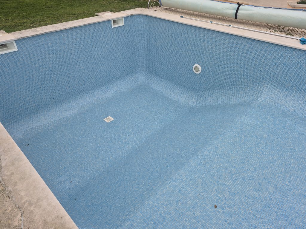 Piscina restaurada com pastilha azul nova pronta para encher